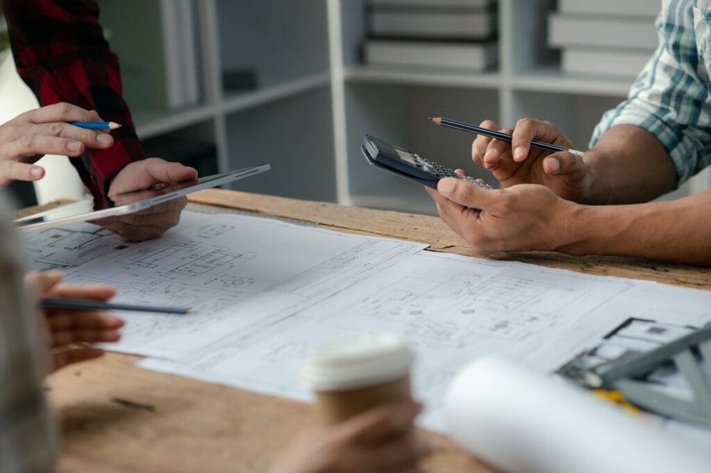 The home design architects are reviewing the house plan draft, the project commissioned by the clien