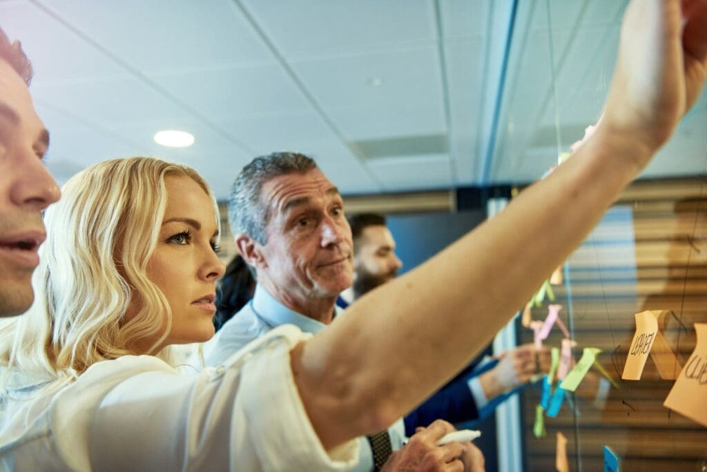 Woman putting sticky note on glass