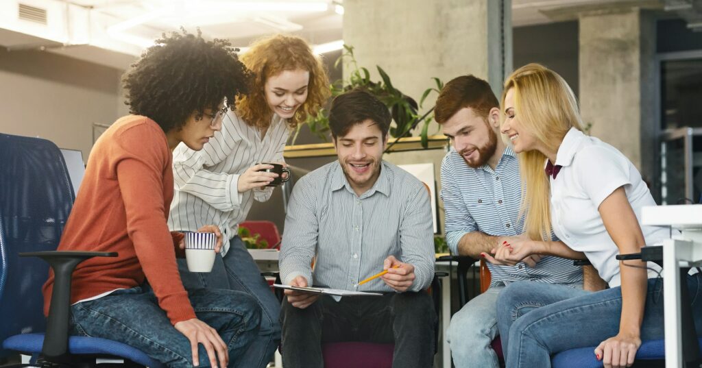 Group of young coworkers discussing new marketing strategy in office