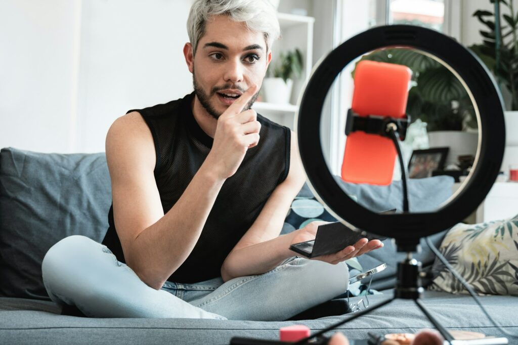Transgender influencer streaming online makeup video on social media at home - Lgbt concept