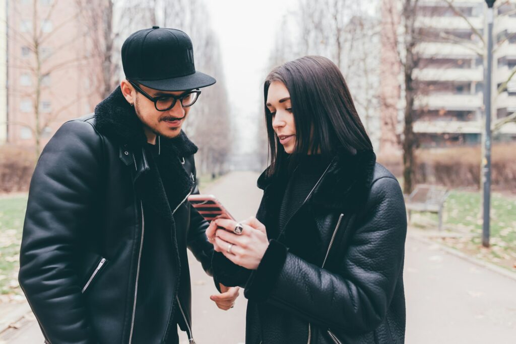Young couple in love outdoor using smartphone