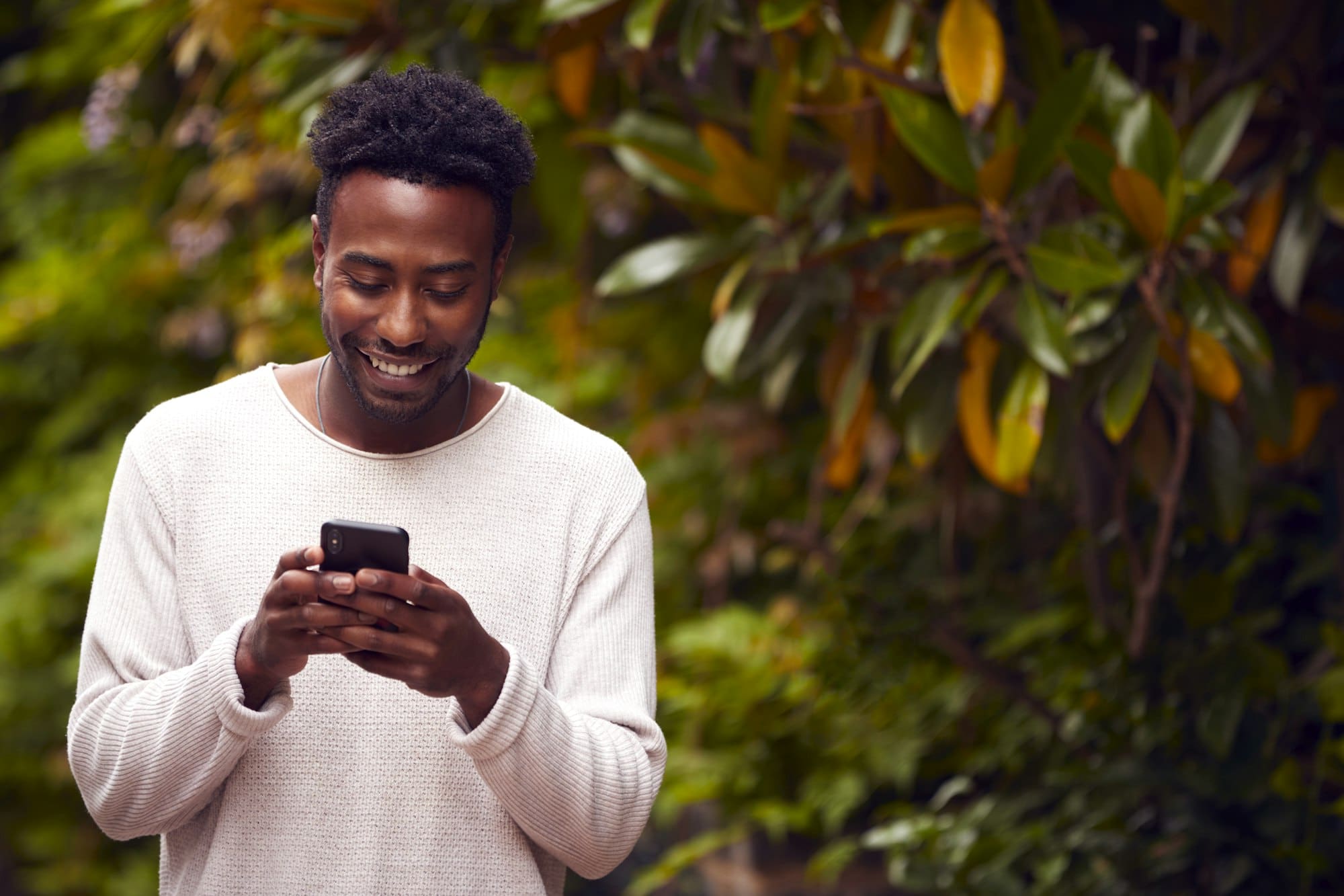 Male Vlogger Or Social Influencer In City Using Mobile Phone On Street To Post To Social Media