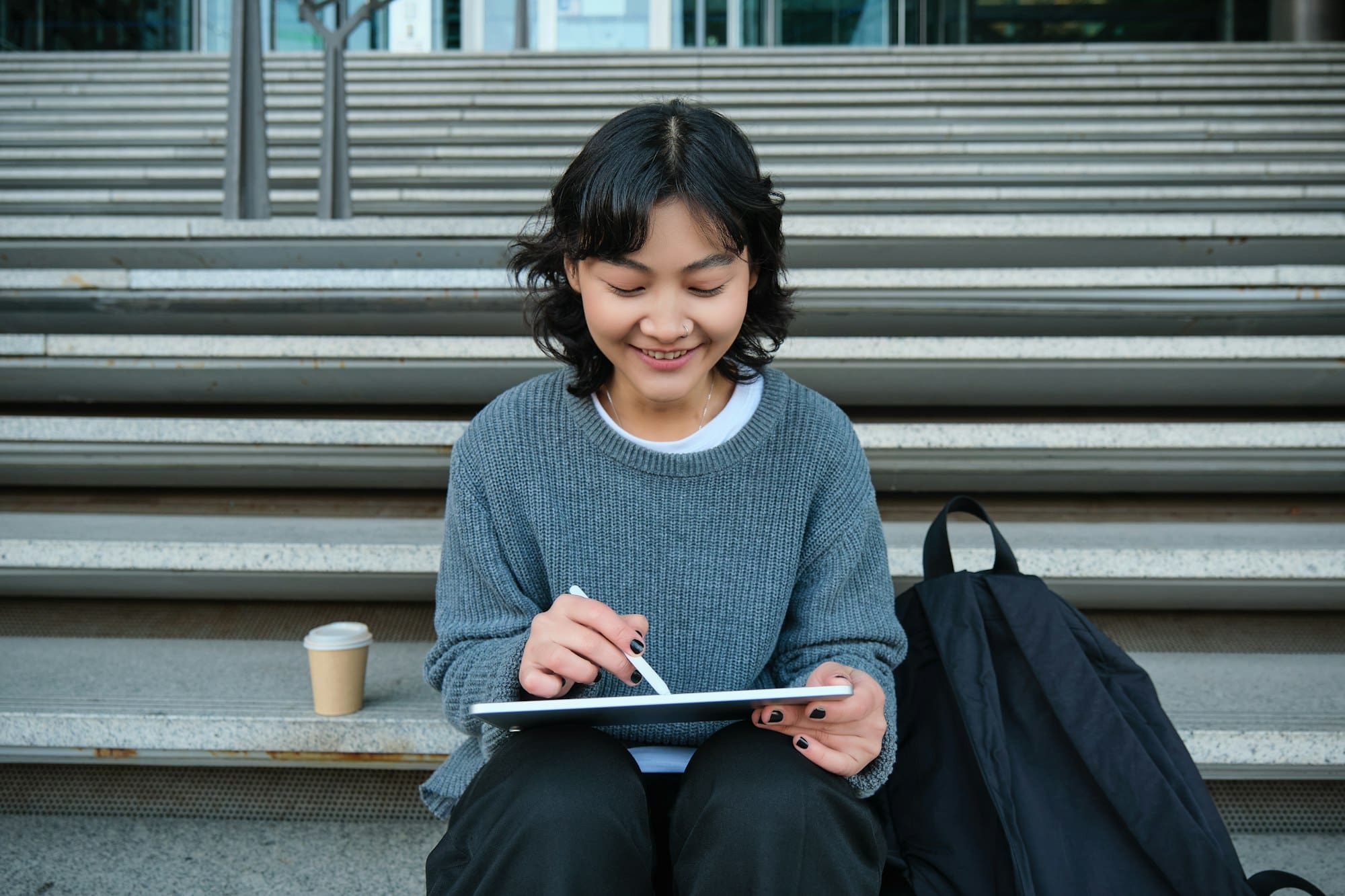 Smiling girl, graphic designer, using digital tablet and pen tool to draw, does home assignment for