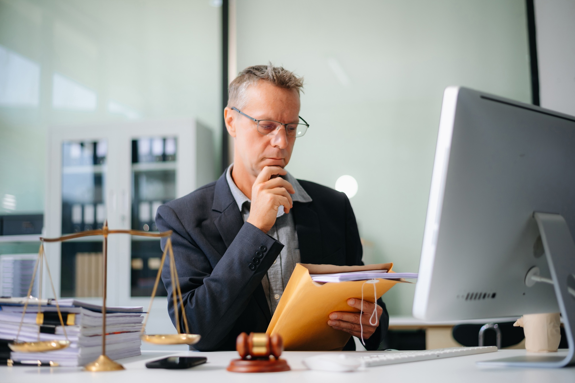 Male lawyer consulting on legal cases in a modern office. Ideal for law firms, corporate attorneys