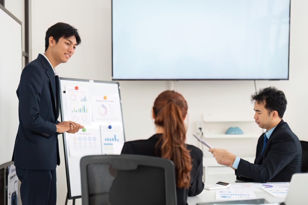 An enthusiastic presenter working with colleagues, focusing on project performance metrics.