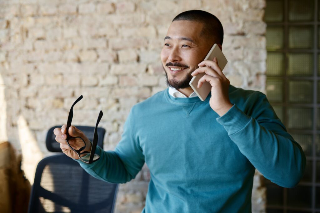 Businessman talking phone with client at coworking office