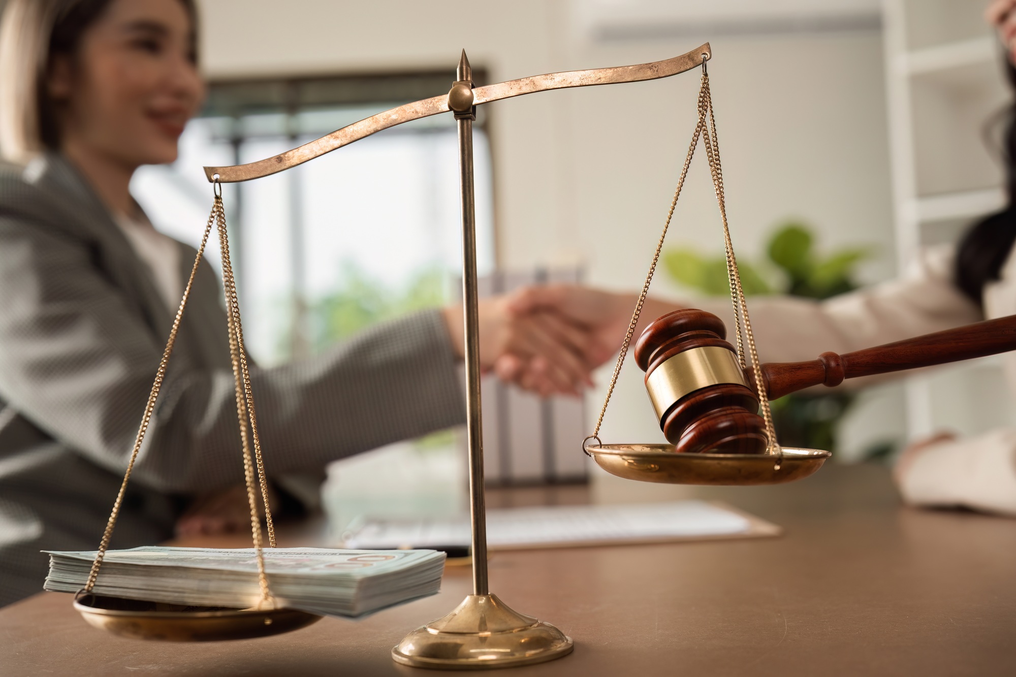 Lawyer and businesswoman shaking hands and reaching an agreement, legal corruption by bribing the