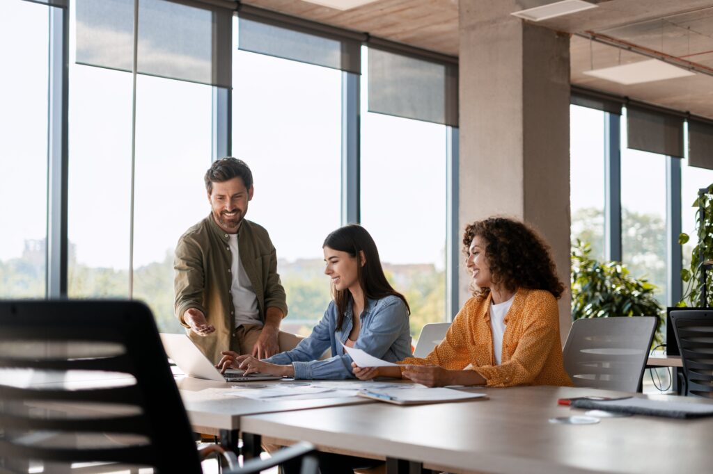 Marketing team working together on a project using laptop in the office